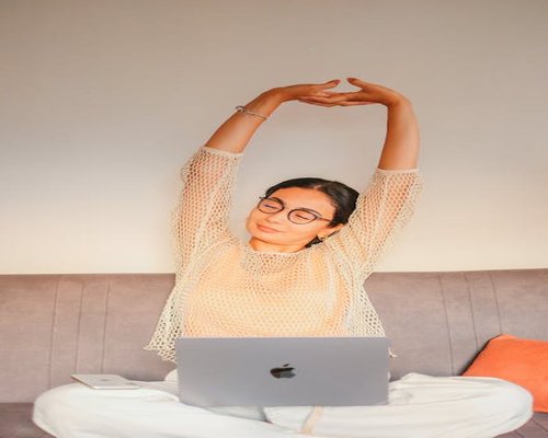 A person working in a modern office setup taking a moment to stretch